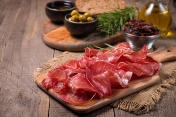 Italian slices of coppa, capocollo, capicollo, bresaola or cured ham with rosemary. Raw food.  