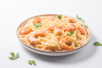 Italian pasta fettuccine or spaghetti in a creamy cheese sauce with shrimp or prawns on a plate