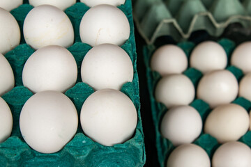 Embalagens de papel&atilde;o recheadas com ovos brancos &agrave; venda na feira.