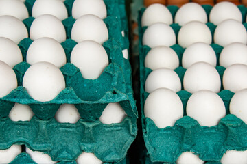 Embalagens de papel&atilde;o recheadas com ovos brancos &agrave; venda na feira.