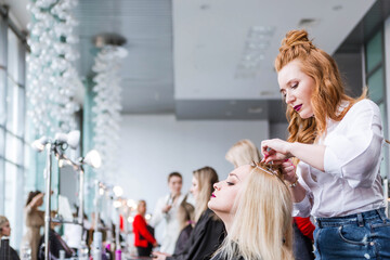 Competition stylists hairdressers at the exhibition of hairstyles and makeup. Participants create...
