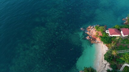 Cinematic footage from height on clear waters of ocean off coast of tropical islands with rocky coast. Aerial view of tourism with a drone. High angle view of an island in the tropics for tourists © ShantiMedia