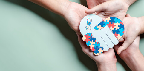 Father, Mother, Children holding heart jigsaw puzzle, Color puzzle symbol of awareness for autism spectrum disorder family support. Autism World Awareness Day.