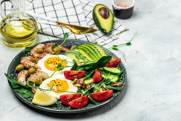 shrimps, prawns, soft fried egg, fresh salad, tomatoes, cucumbers and avocado on a light background. Ketogenic diet breakfast. Keto, paleo lunch. Top view