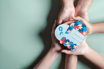 Father, Mother, Children holding heart jigsaw puzzle, Color puzzle symbol of awareness for autism...