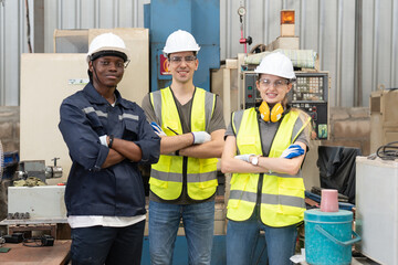 Group of engineers wear helmets safety arms crossed at factory workshop. Technician professional team standing in manufacture industrial