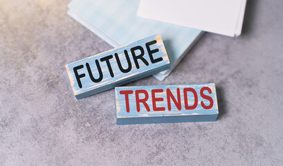 Cropped view of hands holding wooden cube with Future trends lettering on work table. Top view