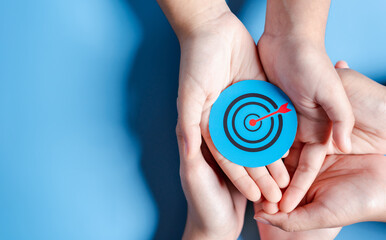 Business hands holding target icon, dartboard and arrow for creative and set up business objective target goal, marketing solution, target for business investment.