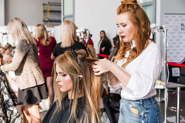 Competition stylists hairdressers at the exhibition of hairstyles and makeup. Hairdressers create...