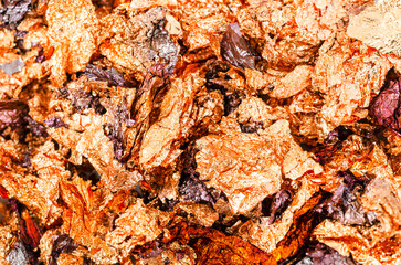 The Background image of crumpled pieces of gold foil in close-up.Macrophotography.