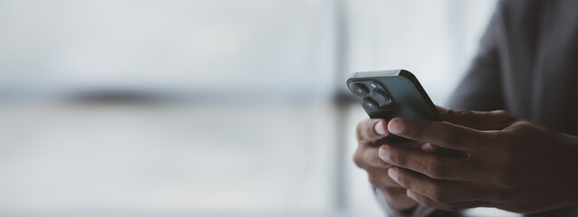 Business man looking at financial information from a mobile phone, he is checking company financial documents, he is an executive of a startup company. Concept of financial management.