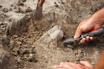 Archaeological excavations, archaeologists work, dig up an ancient clay artifact with special tools