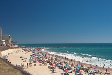People sunbathing in the beach of Santa María in Cádiz