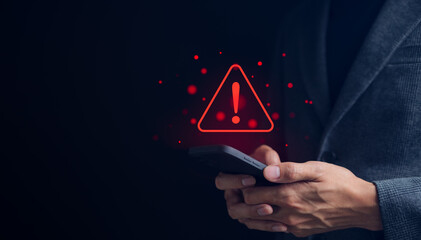 Businessman or User holding smartphone with triangle caution warning sign red for notification error and maintenance concept. warning sign exclamation,