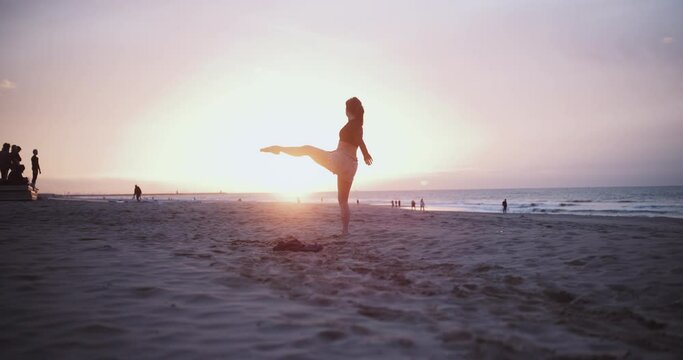 Dancer on beach moves gracefully on beach 