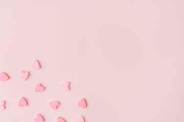 Small hearts in the corner of a pink background.
