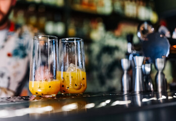 bartender making cocktail with passion fruit in a nightclub bar