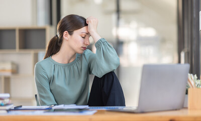 Portrait of tired young business Canada american woman work with documents tax laptop computer in office. Sad, unhappy, Worried, Depression, or employee life stress concept	