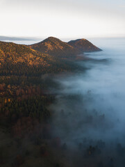 Aerial view of mountains in low clouds at sunrise in autumn season. Transylvania,Romania.