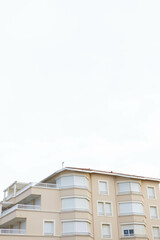 un immeuble d'appartement blanc au premier plan et ciel blanc