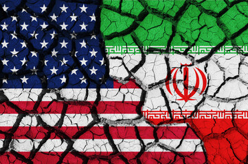 Flag of the United States and Iran on the texture of the cracked dry earth. The concept of conflict between states