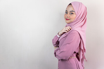Beautiful smiling Asian woman in pink hijab looking confident isolated over grey background