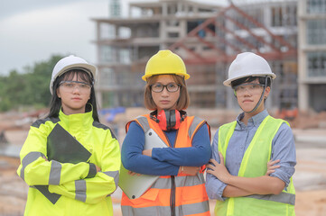 Young and senior Engineers discuss about work of large building underconstruction,Three people working on site of under construction