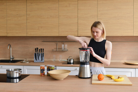 Woman is going to make freshly squeezed juice or smoothie