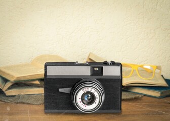 Old fashioned camera on bookshelf with retro books