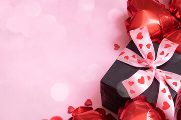 Gift box, candels and red heart shape balloons on pink background with bokeh. Valentines Day concept