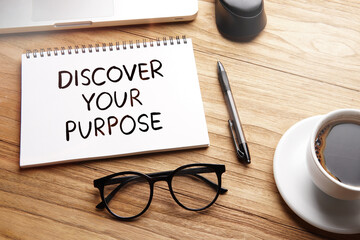 Discover Your Purpose, motivational words and sentences for work and life. Quote sentence in notebook with laptop, pen, coffee over wooden background.