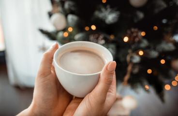 Cup of coffee with christmas tree in background