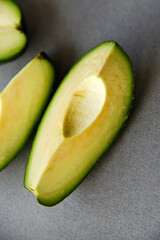 Green avocado fruit cut into slices on a white background. Avocado on a white plate. Avocado slices and halves