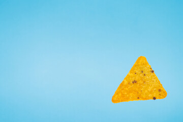 nachos chips isolated on blue background. falling down doritos triangle