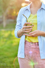 Woman drinking summer citrus lemonade with reusable metal straws party