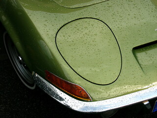 Regentropfen auf der Karosserie eines Sportwagen in grün metallic mit Klappscheinwerfer der...