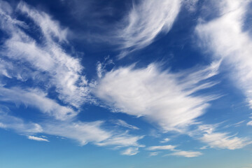 Weiße Federwolken am blauen Himmel, Cirrus-Wolken aus Eiskristallen, die durch Höhenwinde...