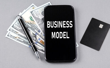 Credit card and text BUSINESS MODEL on smartphone with dollars and pen. Business concept