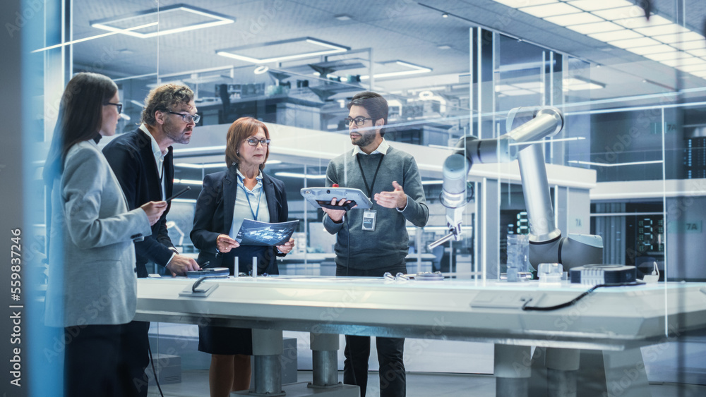 Poster Professional Multicultural Team of Female and Male Engineers Using Industrial Programmable Robotic Arm in a Factory Development Workshop. Tech Facility with Machines, Computers and Research Equipment.