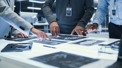 Anonymous Managers Standing Around a Table, Having a Work Meeting, Discussing Blueprints with...