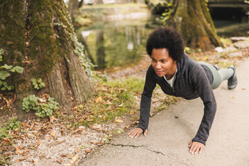 Black Woman Warming Up Before Running In Nature