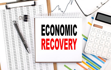 ECONOMIC RECOVERY text on notebook with chart, calculator and pen