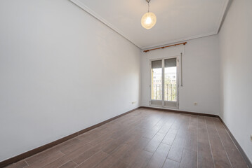 Empty room with dark wood-like stoneware floors and exit to a terrace with aluminum and glass...