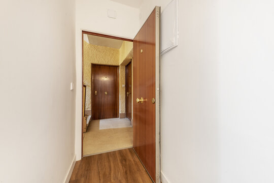 Entrance hall of a detached house with armored doors with sapele paneling and wooden tiled floor