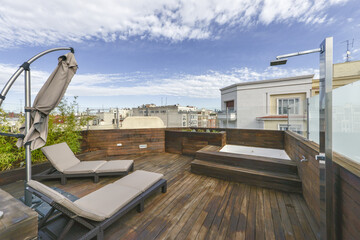 Terrace in penthouse house all covered in acacia wood planks with a jacuzzi, stainless steel shower...