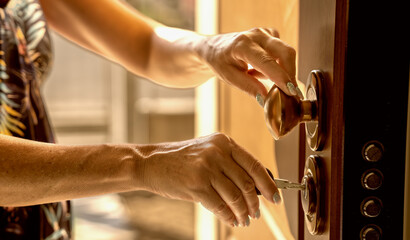 Obraz premium Moving to a new house. Woman hand inserting the new key in the entrance door