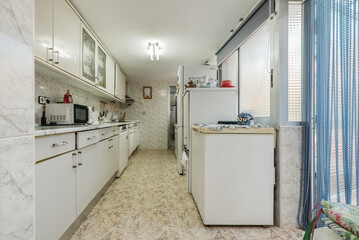 kitchen of a low house with access to a terrace with old furniture and dim light