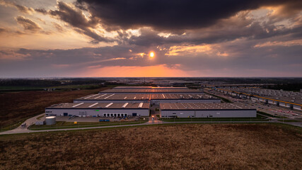 ogromne magazyny centra logistyczne o zachodzie słońca z drona - obrazy, fototapety, plakaty
