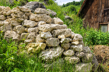 Structure of a stone wall exemplified by one in the front yard of a cottage on the Swabian Alb near Bad Urach, Baden-Wurttemberg, Germany.
