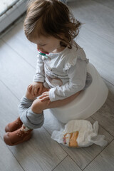potty training small caucasian girl toddler child sitting on the potty